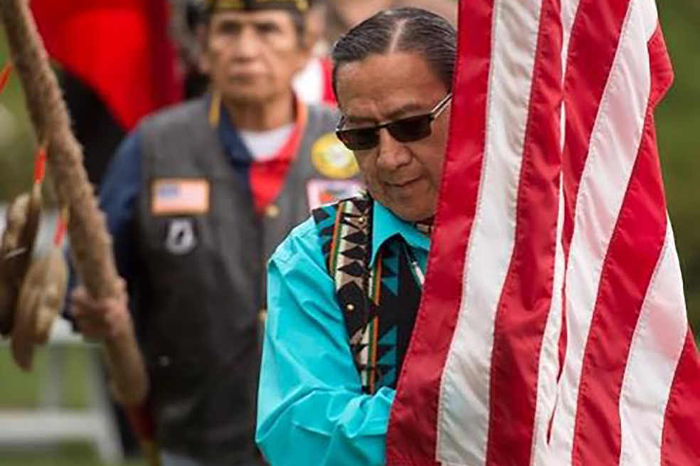 Ground Blessing Ceremony showing man with flag close up