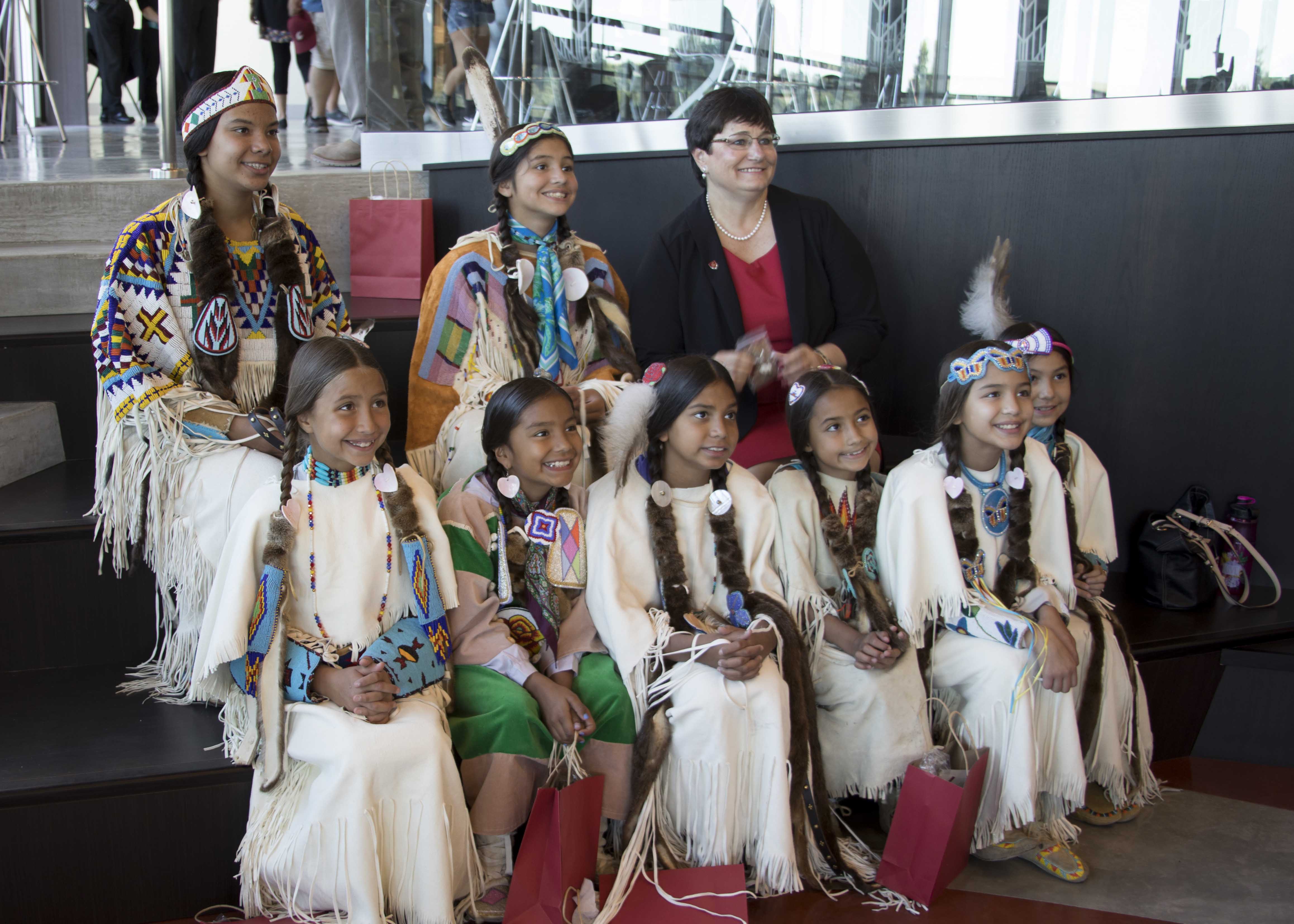 First Lady Noel Schulz seated with young female dancers.