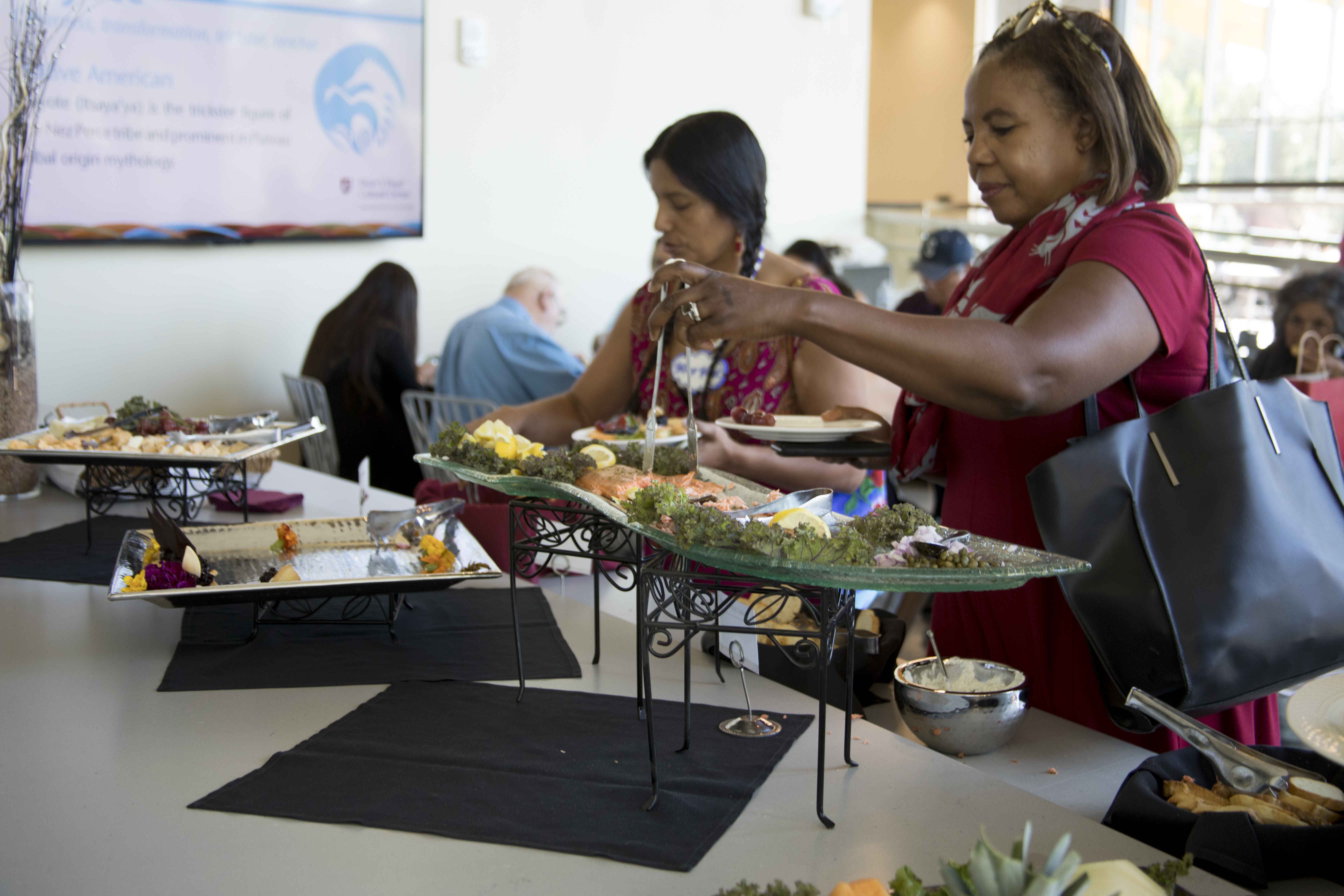 People getting food from the demo kitchen buffet.