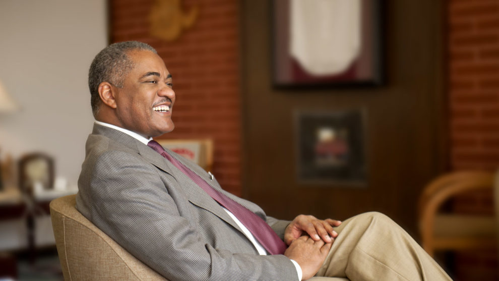 Dr. Floyd smiling, sitting in a chair. 